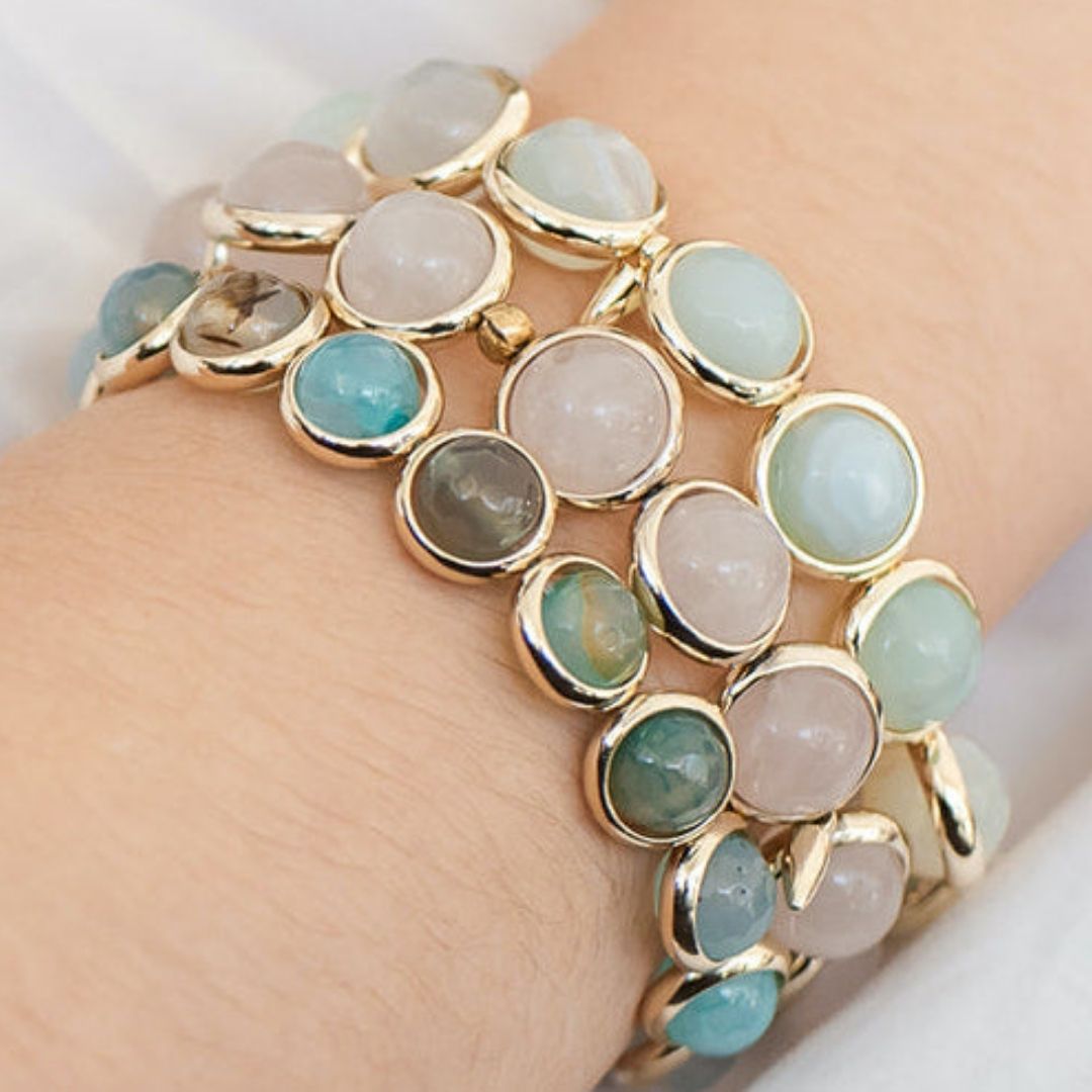 A close-up of a wrist wearing a stacked blue and white gemstone bracelet by Brett Lauren, showcasing a blend of soft, elegant stones.