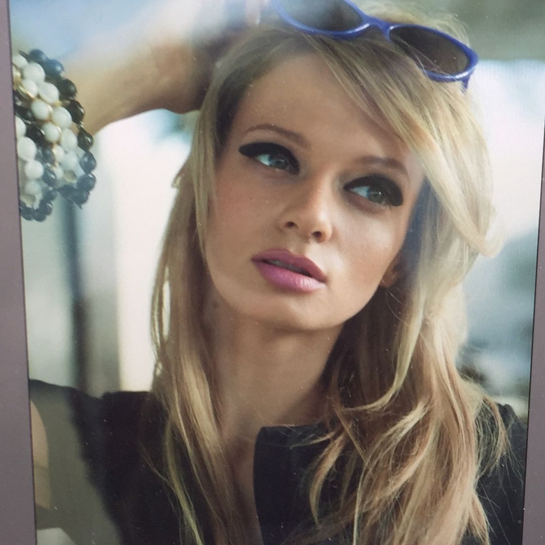 A model wearing a Brett Lauren gemstone bracelet and sunglasses, posing with her hand in her hair, captured in a fashion setting.