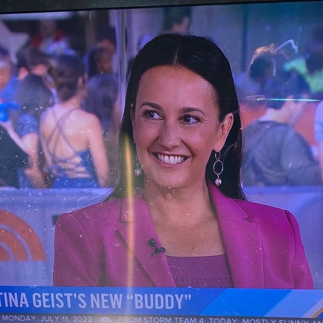 A woman wearing Brett Lauren gemstone bracelets featured on a TV show, smiling while displaying her jewelry.